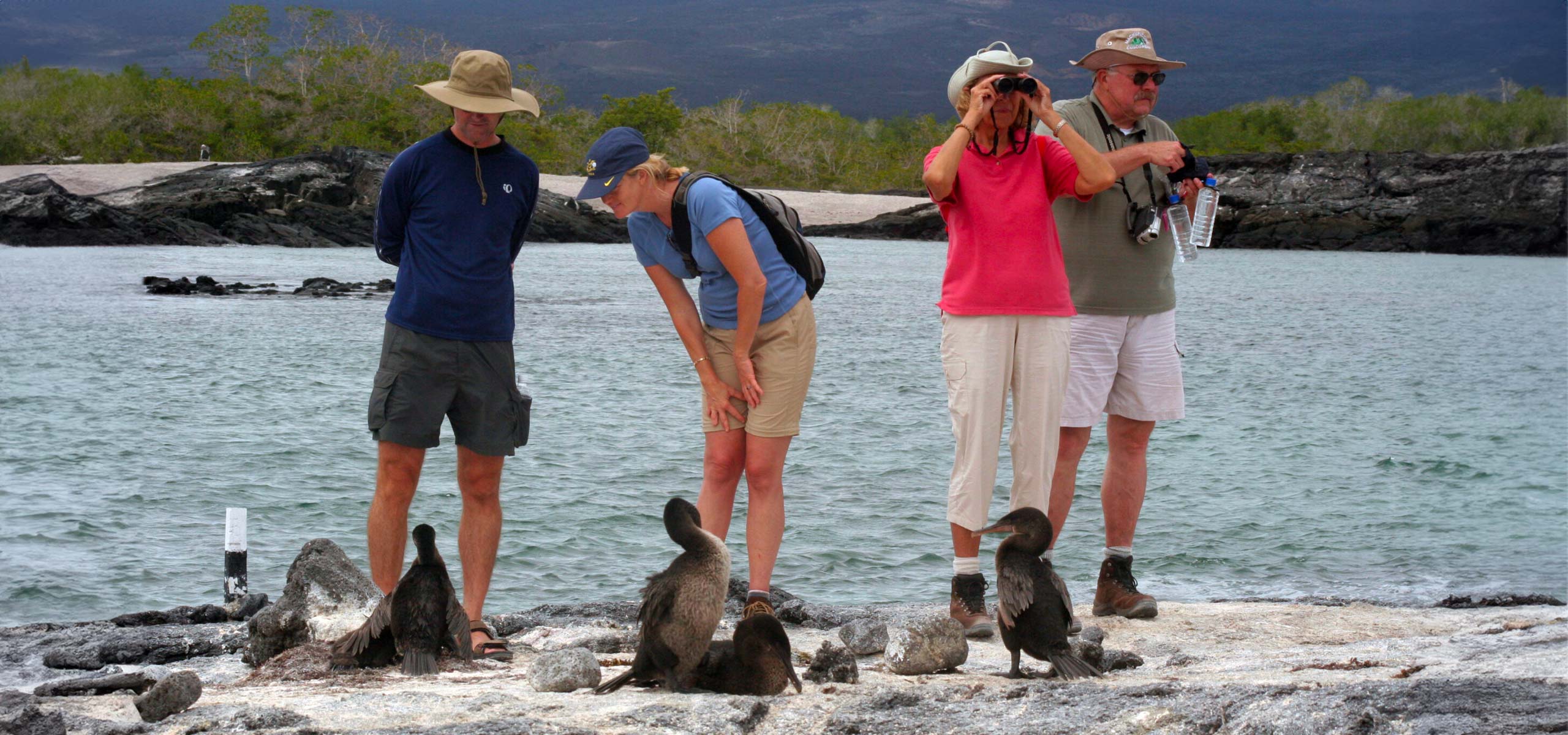 Turistas en galápagos posan frente a piqueros