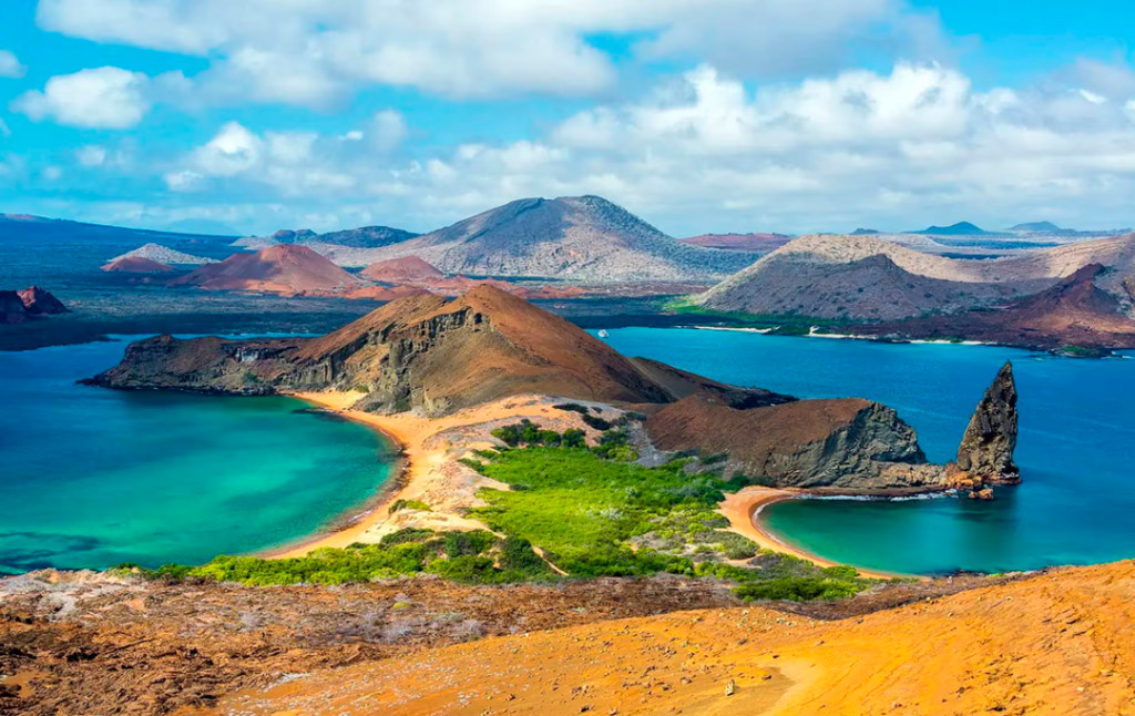 Fotografía panorámica de una parte de las Islas Galápagos donde se aprecia la Punta Pitt junto a la playa Oliviana y al fondo la Isla San Cristóbal
